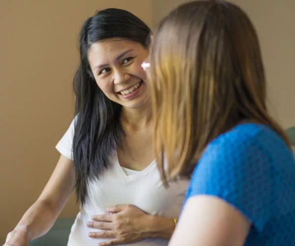 Kobieta w ciąży rozmawia z drugą kobietą